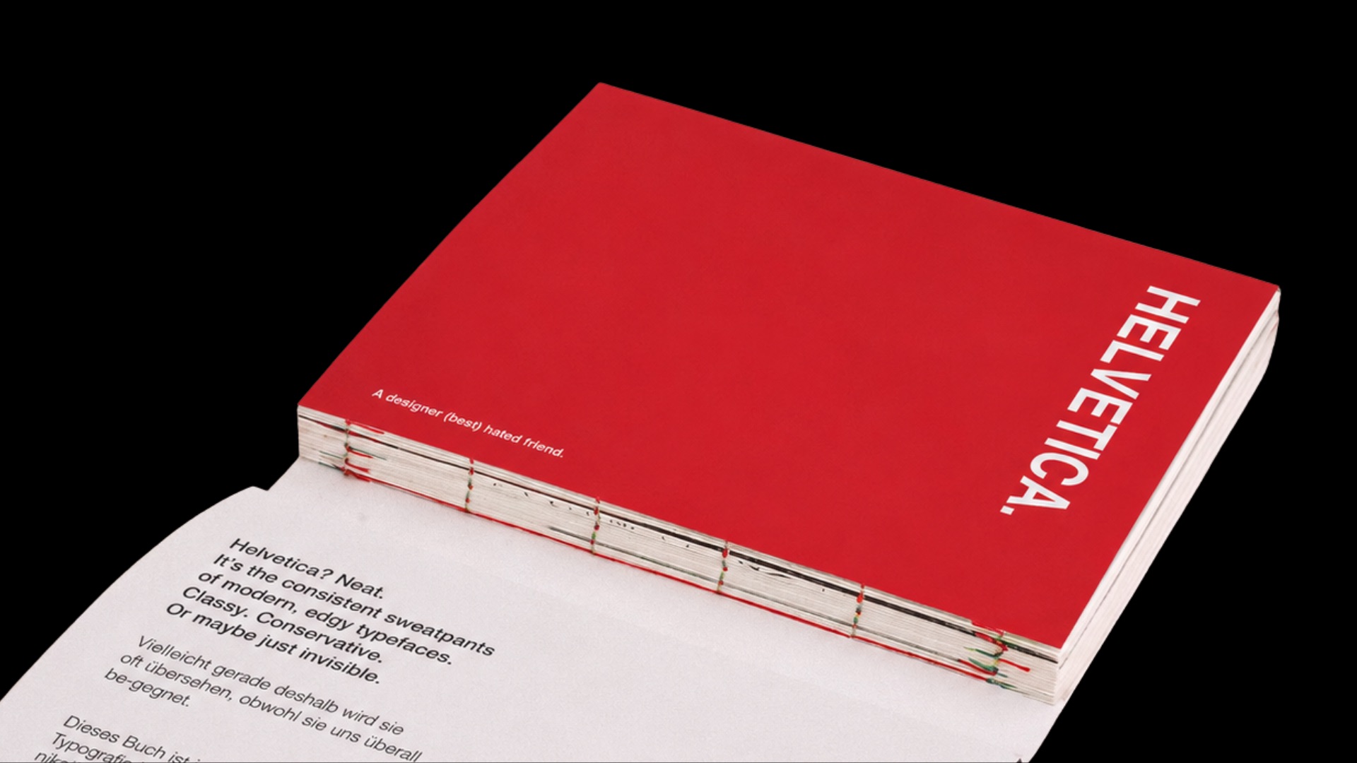 The finished book on a black ground: red cover with HELVETICA. and the line A designer (best) hated friend, opened at a spread